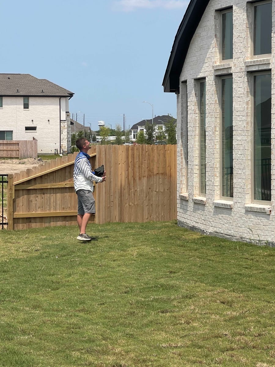 Home inspector examining shingles and flashing on a Pearland TX roof