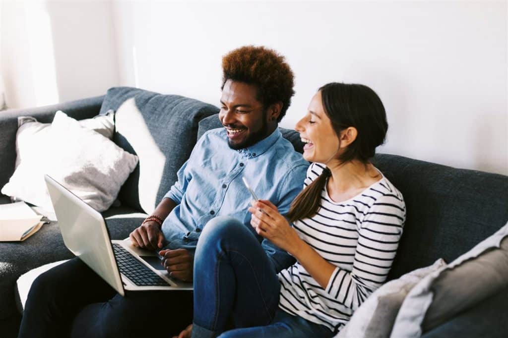 couple with laptop and cellphone | GC Home Inspection | home buying Pearland