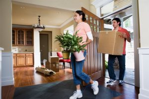 a man and a girl moving plants and carton inside the house | GC Home Inspection | Door Pearland