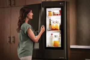 a woman opening a fridge | GC Home Inspection | Kitchen Pearland