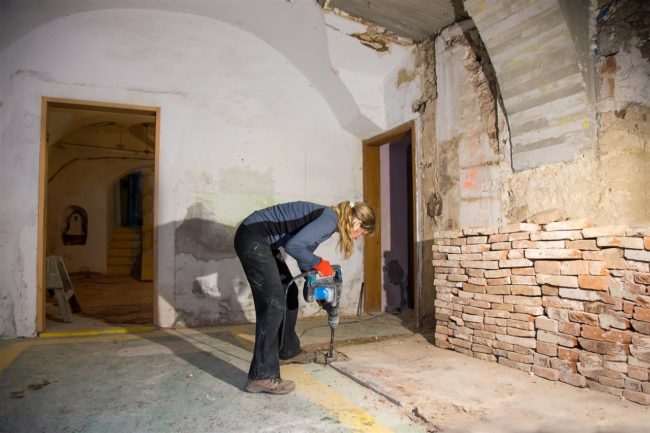 woman drilling the basement floor | GC Home Inspection | Bathroom in the basement Pearland